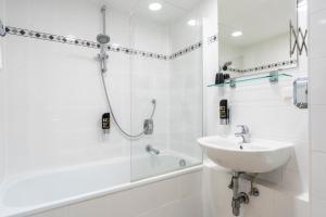 a white bathroom with a sink and a shower at Hotel Enziana Wien in Vienna +87 photos