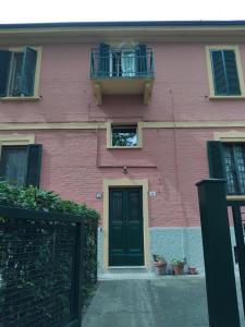 a pink building with a black door and a balcony at Sogni in soffitta in Casalecchio di Reno