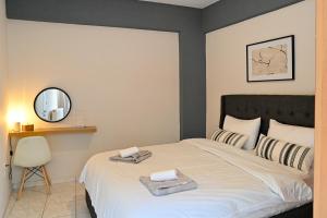 a bedroom with a bed with a mirror and a chair at CALLI HOUSE in Preveza