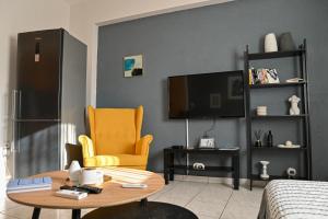 a living room with a table and a tv at CALLI HOUSE in Preveza