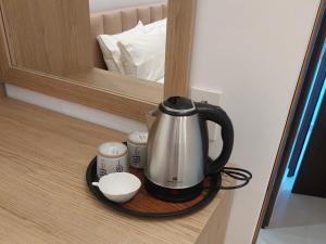 a tea kettle and cups on a shelf in a mirror at Laertis house in Himare