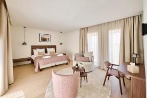 ein Schlafzimmer mit Bett und ein Wohnzimmer in der Unterkunft Hôtel Éole Resort - Mons - Shape - Pairi Daiza in Warchaix