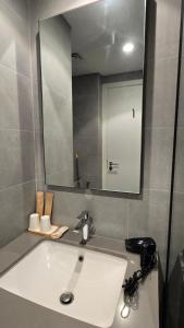 a bathroom with a white sink and a mirror at Kuro Homes in Sharjah