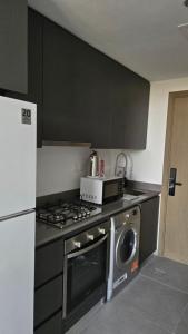 a kitchen with a stove and a microwave at Kuro Homes in Sharjah +9 photos