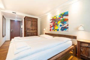 a bedroom with two beds and a painting on the wall at Hotel Enziana Wien in Vienna