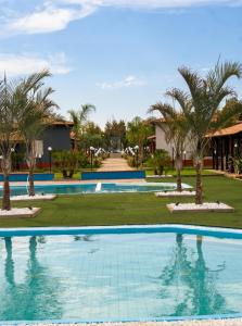 a large swimming pool with palm trees in a resort at House Betania in San Ferdinando