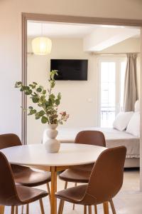 a dining room with a table and chairs and a bed at Aesop Homes in Pythagoreio