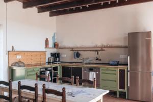 a kitchen with green appliances and a table with chairs at Saint Germain - Logis de Beaulieu in Poullignac