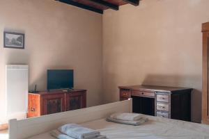 a bedroom with a bed and a desk and a television at Saint Germain - Logis de Beaulieu in Poullignac