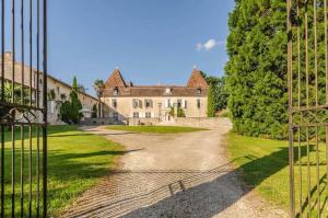 an open gate to a large house with a yard at Saint Germain - Logis de Beaulieu in Poullignac