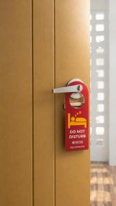 a door with a do not disturb sign on it at OneVillaResort in Ban Son Tap Tao