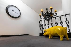 a yellow pig statue in a room with a clock at RM The Experience - Small Portuguese Hotels in Setúbal