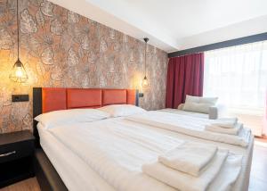 a bedroom with two beds with white towels on them at Hotel Enziana Wien in Vienna