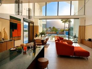 a living room with orange furniture and a large window at Luxury Villa Galaxy Beach 12min walk 15m pool in Calpe