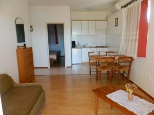 a living room with a table and chairs and a kitchen at Apartments Skender in Čižići