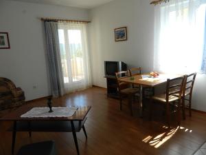 a living room with a table and a dining room at Apartments Skender in Čižići