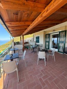 a patio with tables and chairs and the ocean at B&B Saracinello in Praia a Mare