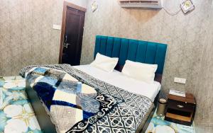 a bed with a blue headboard in a room at Agrawal seva sadan in Mathura