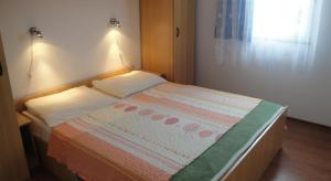 a small bed in a room with a window at Apartments Skender in Čižići