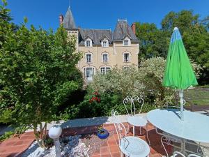 an umbrella and tables in front of a building at Château de Villechauvon in Vatan