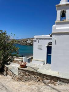 a small white building with a blue door and water at Saint Nectaire in Kardhianí