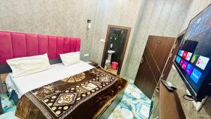 a bedroom with a bed with a pink head board at Agrawal seva sadan in Mathura
