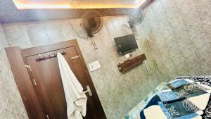 a bathroom with a brown door and a mirror at Agrawal seva sadan in Mathura +13 photos