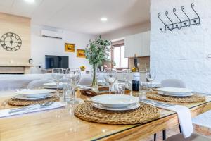 a dining room table with plates and glasses on it at Casa Rural Casita de la Cantera in La Lantejuela