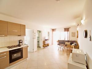 a kitchen and a living room with a couch at Bayview Bliss Appartement just 50 steps from the beach in Santa Maria