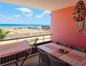 a table and chairs on a balcony with a view of the beach at Bayview Bliss Appartement just 50 steps from the beach in Santa Maria +16 photos