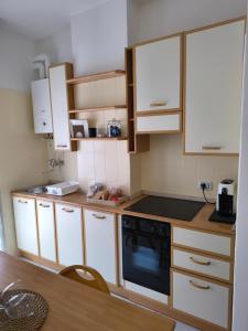 a kitchen with white cabinets and a black stove at Il sorriso romagnolo in Misano Adriatico