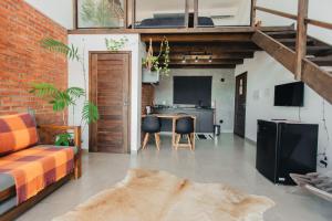 a living room with a bed and a table with chairs at The Guest House pousada in Balneário Gaivotas