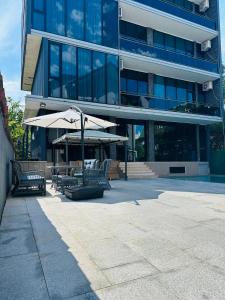 a building with a table and umbrella and chairs at House nucii in Kobuleti