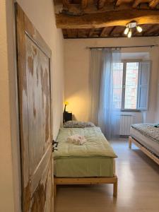 a bedroom with a bed and a window and a door at Casa in Corso, Colle Val d'Elsa in Colle di Val d'Elsa
