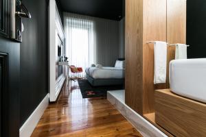 a bathroom with a sink and a couch in a room at RM The Experience - Small Portuguese Hotels in Setúbal