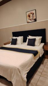 a large bed with white sheets and blue pillows at أبو بندر للشقق المخدومة in Ar Rass +9 photos