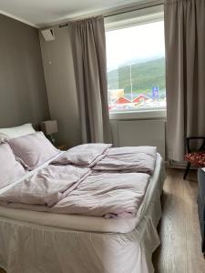 niepościelone łóżko w sypialni z oknem w obiekcie Leilighet Hemnesberget- Sørlandsvegen 15 B w mieście Hemnesberget
