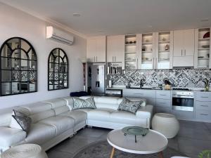 a living room with a white couch and a kitchen at Shelley Point On Sea in St. Helena Bay