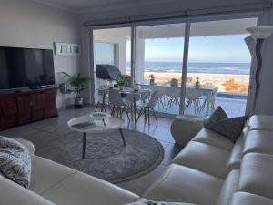 a living room with a white couch and a view of the ocean at Shelley Point On Sea in St. Helena Bay
