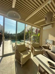 a living room filled with furniture and a large window at Villa RRE Green Coast in Palasë