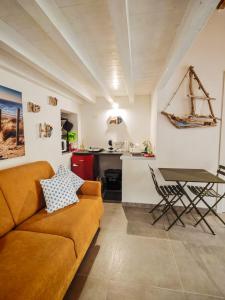 a living room with a couch and a table at Casetta Ismeralda in Carloforte +6 photos