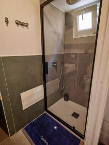 a bathroom with a shower with a blue floor at Casetta Ismeralda in Carloforte