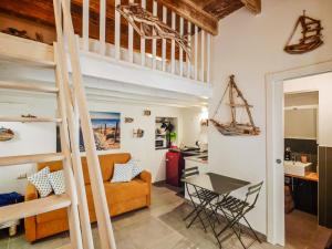 a room with a loft bed and a table and chairs at Casetta Ismeralda in Carloforte