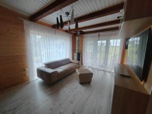 a living room with a couch and a flat screen tv at Family vacations house in Tīnūži