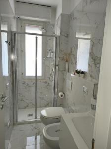a white bathroom with a toilet and a shower at Il sorriso romagnolo in Misano Adriatico
