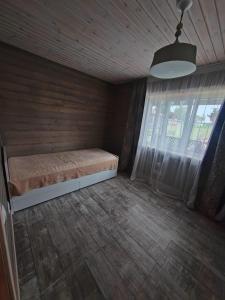 a small bedroom with a bed and a window at Family vacations house in Tīnūži +10 photos