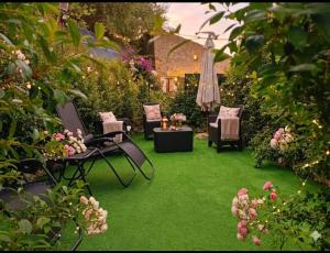 een tuin met groen gras, stoelen en bloemen bij La Pace in Savoca 