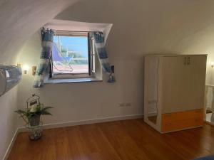a room with a window and a dresser in a room at L'Angolo Vacation Home in Nerano