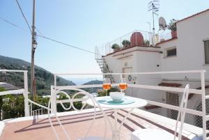 a balcony with a table and two glasses of wine at L'Angolo Vacation Home in Nerano