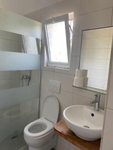 a white bathroom with a toilet and a sink at Green House in Himare